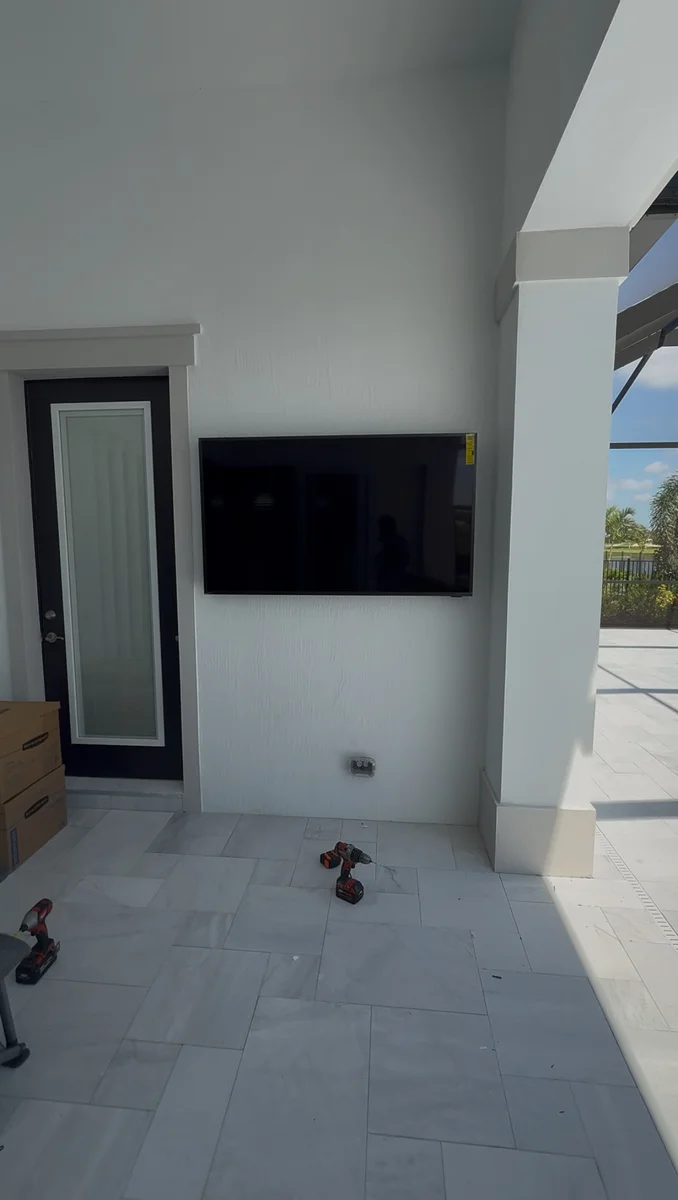 Wall-mounted outdoor television installation on covered patio of a Miami residence