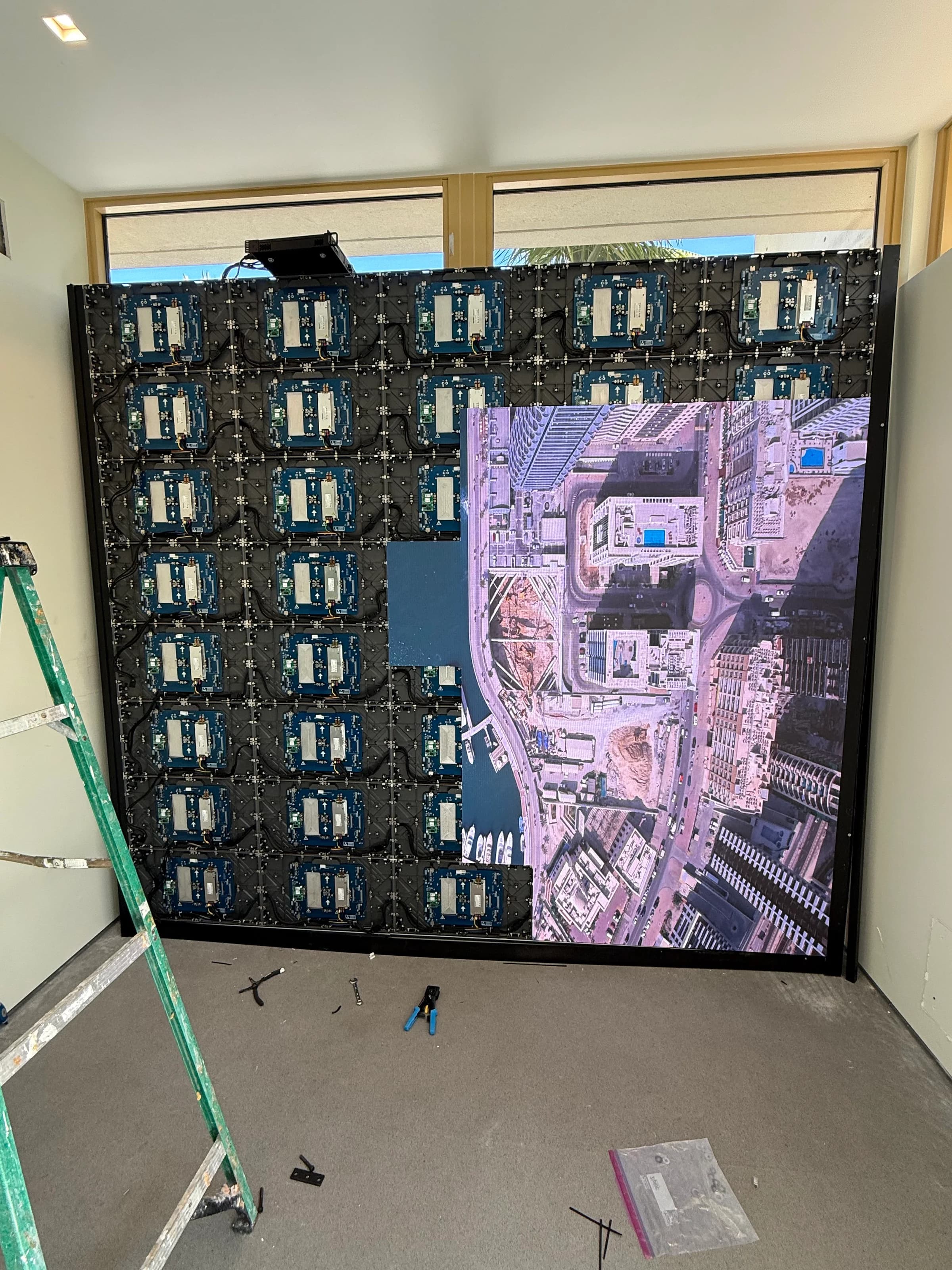 LED video wall mid-calibration showing aerial cityscape on top half