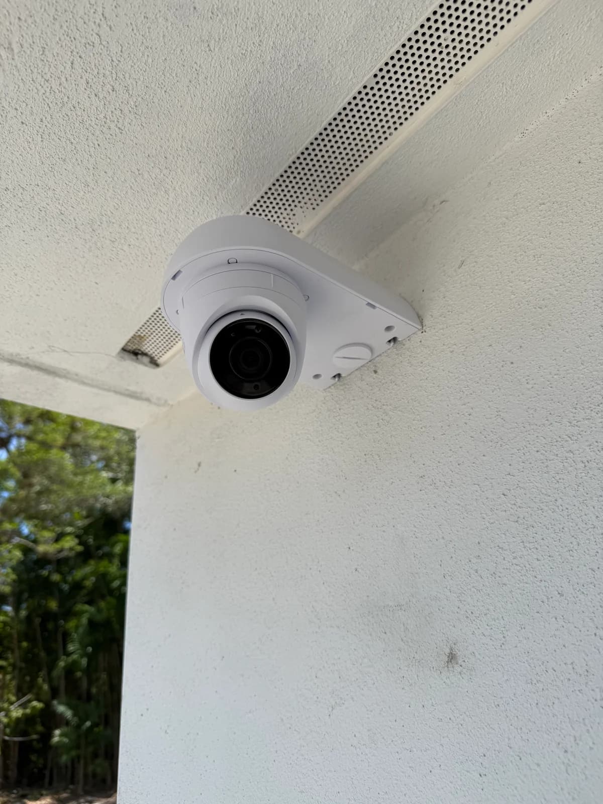 Professional Ubiquiti UniFi dome security camera installation under stucco soffit, Miami-Dade residence