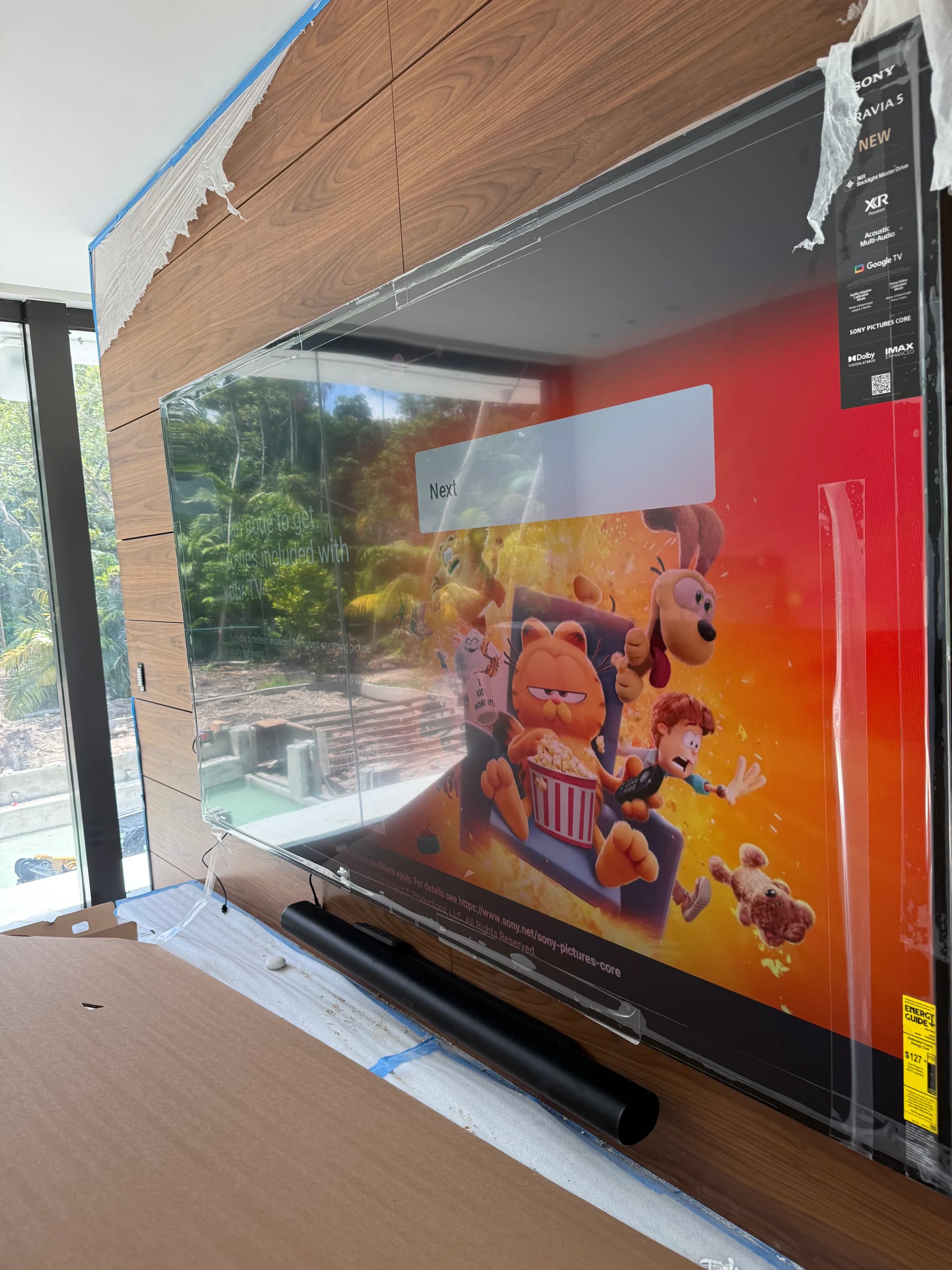 Sony Bravia television displaying content on custom walnut media wall, finished installation