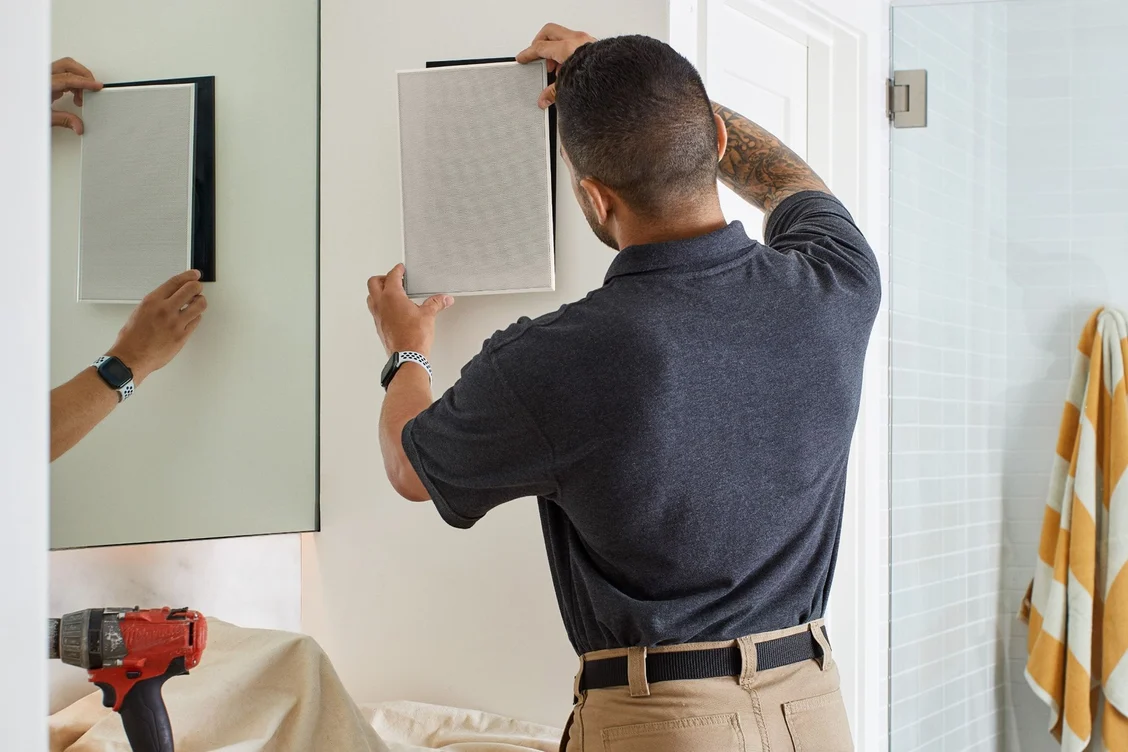 An installer fitting an architectural speaker